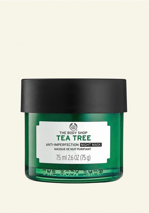 Climbing A Tree At Night To Get Perfected Skin | The Body Shop Tea Tree Anti-Imperfection Night Mask A short cylindrical clear glass jar full of some dark green liquid with a dark green plastic lid and a dark green label that has The Body Shop Tea Tree Anti-Imperfection Night Mask written in bright white writing on it, on a white background.
