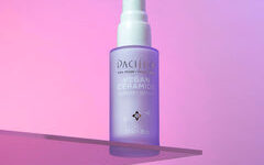 A short cylindrical clear Glass Bottle full of some pale purple liquid with a white Rubber Pipette Lid and a white label that has Pacifica Vegan Ceramide Barrier Serum written in bold black writing on it, on a white background.