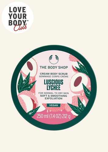 Walking Through A Grove Of Luscious Lychee Trees This Summer | The Body Shop Luscious Lychee Range A short cylindrical dark green plastic tub with a dark green plastic lid and a bright pink label that has The Body Shop Luscious Lychee Body Scrub written in dark green writing and some pictures of some bright pink slices of Lychee on it, on a white background.