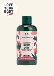 A tall cylindrical dark green plastic bottle with a dark green plastic lid and a bright pink label that has The Body Shop Luscious Lychee Shower Cream written in dark green writing and some pictures of some bright pink slices of Lychee on it, on a white background.