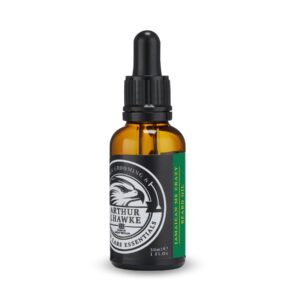 A short cylindrical brown glass bottle with a black rubber pipette lid and a black label that has Arthur J Hawke Jamaican Me Crazy Beard Oil written in bold white writing and a picture of a black and white hawk on it, on a white background.