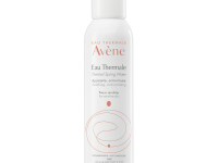 A tall cylindrical metallic white Metal canister with a black plastic lid that has Avène Thermal Spring Water spray written in bright orange writing on it, on a white background.