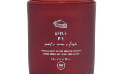 A tall cylindrical dark red glass jar with a dark red glass lid and a dark red label that has DW Home Candles Apple Pie written in bright white writing and a picture of an Apple Pie on it, on a white background.
