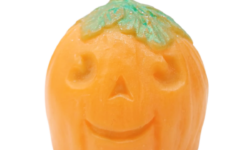 A large bright orange spherical Pumpkin shaped block of soap with a dark green stalk that has a smiley face engraved on it, on a white background.