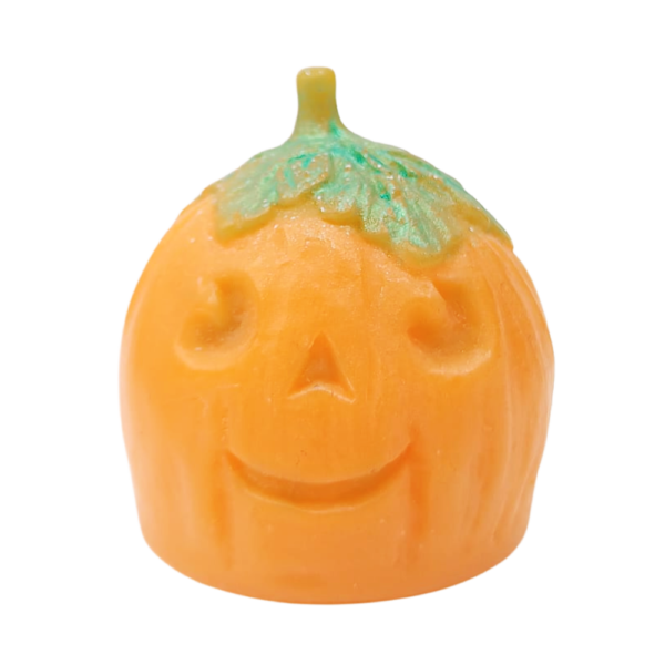 A large bright orange spherical Pumpkin shaped block of soap with a dark green stalk that has a smiley face engraved on it, on a white background.