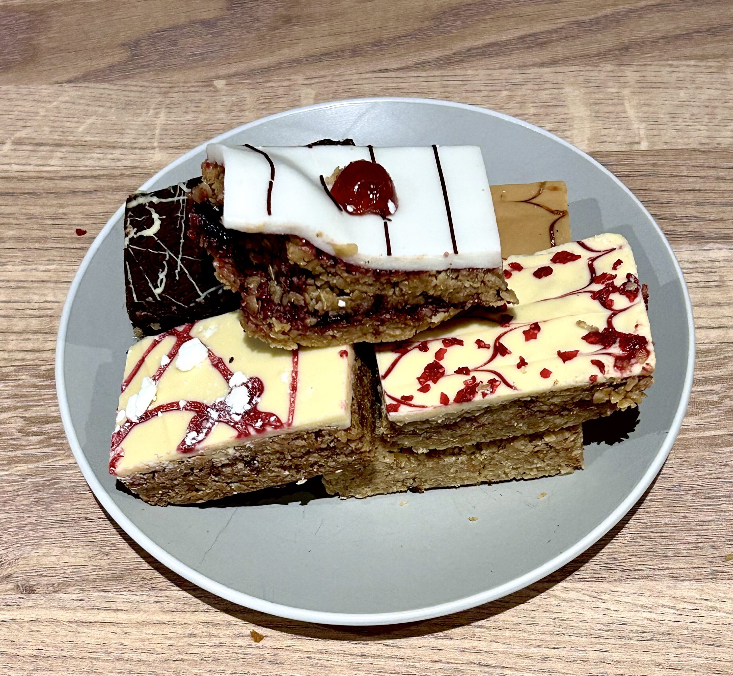 Even Jack Deserves A Little Treat Now And Then | Fancy Jacks 6 Jack Treat Box A collection of six medium rectangular golden brown pieces of Flapjack on a small circular light grey plate, on a white background.