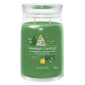 A tall cylindrical glass jar full of some dark green wax with a label that has Yankee Candle written in white writing, Shimmering Christmas Tree written in black writing, and a picture of a large dark green christmas tree covered in some multicoloured christmas ornaments surrounded by some different shaped multicoloured Christmas presents on it, on a white background.