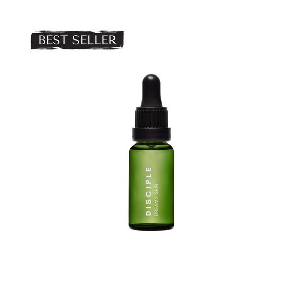 Worshiping At The Feet Of Youthful-Looking Skin | Disciple Dreamy Skin Retinyl Oil A short cylindrical dark green glass bottle with a brown rubber pipette lid and a black label that has Disciple Dreamy Skin Retinyl Oil written in bright white writing on it, on a white background.
