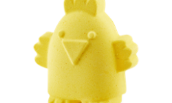 A small bright yellow chick shaped bath bomb that has some bright yellow outstretched wings, on a white background.