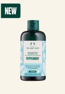 A tall cylindrical dark green plastic Bottle with a dark green plastic lid and a gradient bright blue and white label that has The Body Shop Peppermint Invigorating Shower Gel written in dark green writing and some pictures of some dark green mint leaves on it, on a white background.