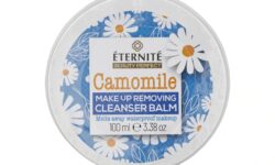 A medium circular metallic dark blue tin with a bright white label that has Éternité Beauty Perfect Chamomile Make Up Removing Cleansing Balm written in bright white writing and some pictures of some bright yellow chamomile flowers on it, on a white background.