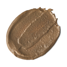 Life Is A Rollercoaster, Just Gotta Ride It | Lush Ayesha Face Mask A medium circular puddle of some creamy brown face mask that has some pieces of bright white Asparagus running through it, on a white background.