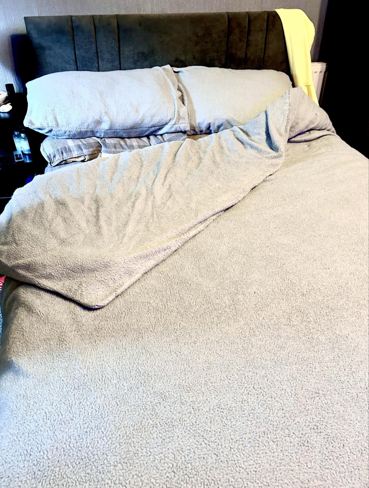 Roaring Out Of Bed In The Morning | Simba Sleep Hybrid® Mattress Topper | Gifted A large rectangular double Bed with a large rectangular plush dark grey headboard and some fluffy dark grey cushions that's covered in a large fluffy dark grey duvet cover, on a white background.