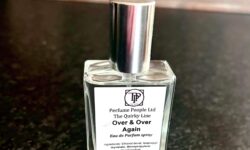 A short square glass bottle full of some clear liquid with a silver metal lid and a white label that has The Perfume People The Quirky Line Time And Time Again Eau De Parfum Spray written in bold black writing on it, on a white background.