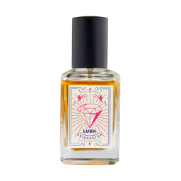 A short rectangular glass perfume bottle full of some translucent amber liquid with a metallic black lid and a white label that has Lush | Bridgerton perfume written in bold black writing and a picture of a Diamond on it, on a white background.