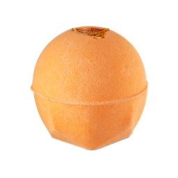 A medium dark orange rounded hexagonal shaped bath bomb that has an orange slice embedded on top of it, on a white background.