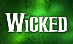 A Poster that has Wicked written in bold bright white writing and a picture of a dark green witch flying on a broomstick over the letter I on it, on a mystical gradient bright and dark green background.
