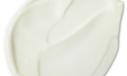 A medium circular puddle of some creamy white cleanser, on a white background.