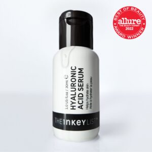 A short cylindrical white plastic bottle with a black plastic lid and a black label that has The INKEY List Hyaluronic Acid Serum written in bold black writing on it., on a white background.