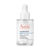 A short cylindrical clear glass bottle full of some clear liquid with a bright white rubber pipette lid and a bright white label that has Avène written in bright red writing, Hydrance Boost written in dark blue writing, and Serum written in bold black writing on it, on a white background.
