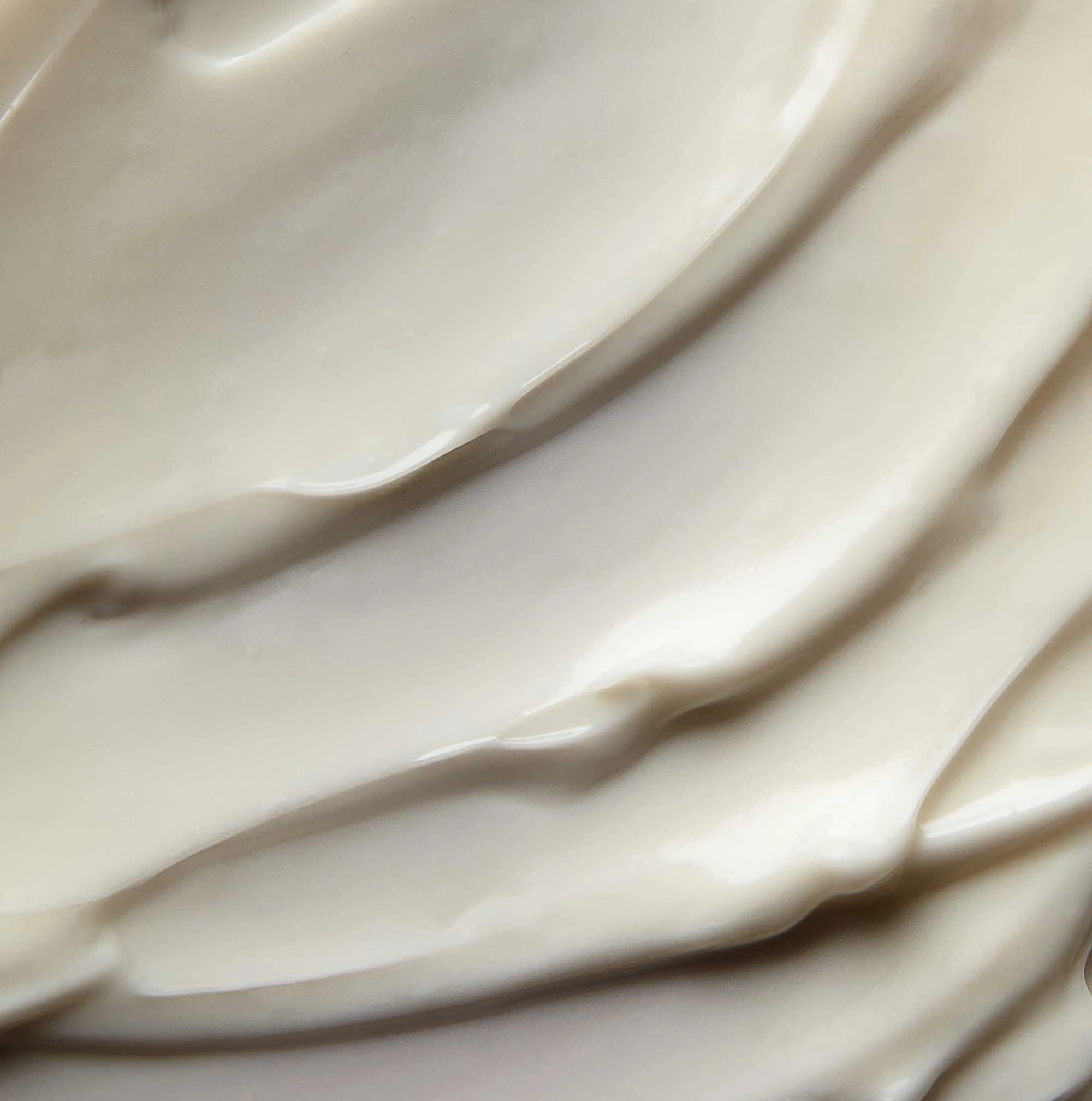 Using Marine Collagen To Get Plumped & Younger-Looking Skin | Elemis Pro-Collagen Marine Cream SPF 30 Anti-Wrinkle Day Cream A medium circular puddle of some glossy creamy beige Moisturiser, on a white background.