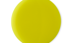 A medium circular puddle of some neon yellow shower cream, on a white background.