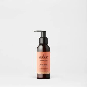 A short cylindrical dark brown plastic bottle with a black plastic pump lid and a peachy pink label that has Sukin Radiance Gel Cleanser written in bold black writing on it, on a white background.
