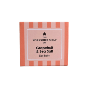 A short square bright peach cardboard box that has The Yorkshire Soap Company Grapefruit & Sea Salt Lip Balm written in bold black writing and a picture of a black crown on it, on a white background.