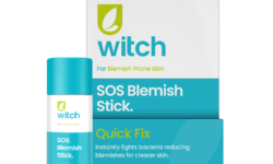 A short cylindrical bright white cardboard tube with an aqua blue cardboard lid that has Witch SOS Blemish Stick written in bright teal writing and a picture of a dark green leaf on it, on a white background.