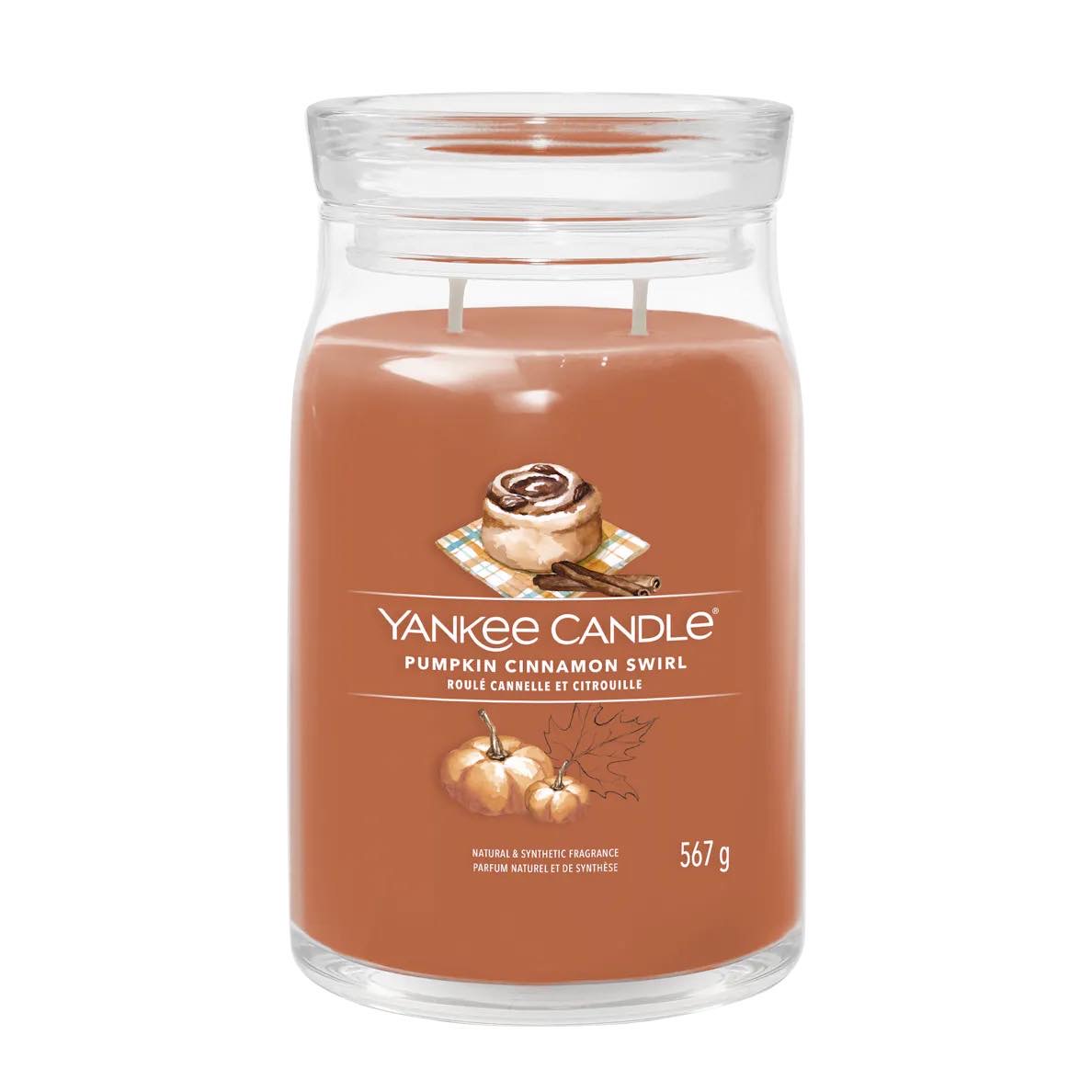 What I Thought of the Yankee Candle Advent House 2014 A tall cylindrical glass jar full of some dark pumpkin orange wax with a label that has Yankee Candle written in bright white writing, Pumpkin Cinnamon Swirl written in bright white writing, and a picture of a golden brown cinnamon roll on top of a blue and white checkered napkin next to some dark brown cinnamon sticks on it, on a white background.