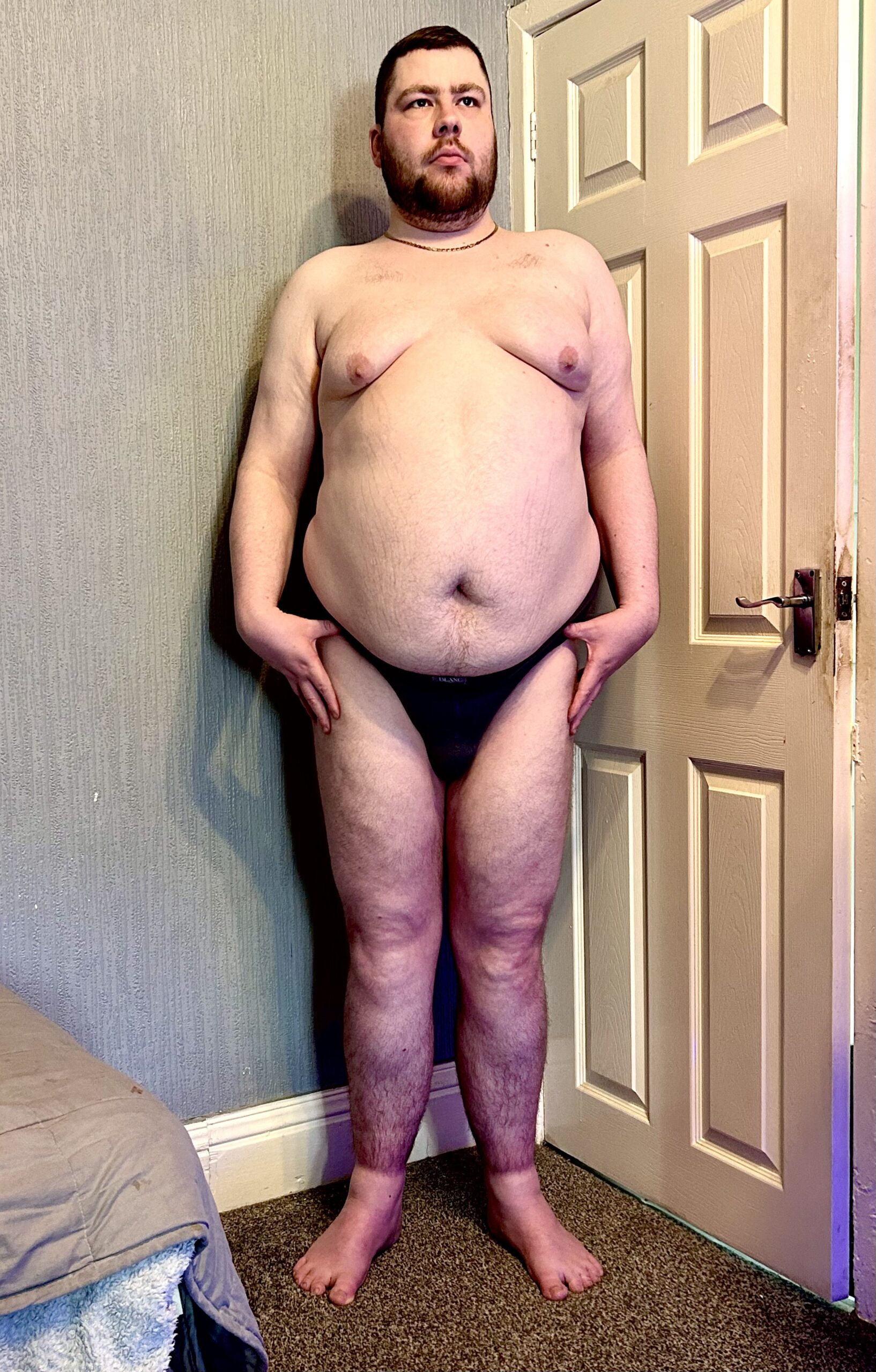 Don't Touch Those Buns, They're Hot | Blanc Menswear Charcoal Touch Me Briefs A tall bearded man with his hands on his hips wearing a pair of charcoal grey briefs with a charcoal grey waistband that has Blanc Menswear written in bright white writing on it stood against a white wooden door.