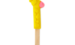 A large bright yellow giraffe’s head and neck shaped bubble bar that has some spots and a pink mouth engraved on it on the end of a light wooden stick, on a white background.