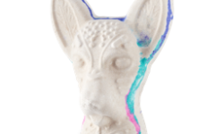 A medium bright white Mexican hairless dog’s head shaped bath bomb that has a bright blue, pink and teal outline around it, on a white background.