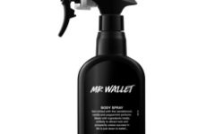 A tall black plastic Kitchen spray bottle that has Lush Mr Wallet Body Spray written in bright white writing on it, on a white background..