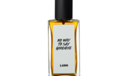 A short rectangular glass perfume bottle full of some translucent amber liquid with a metallic black lid and a white label that has Lush No Way To Say Goodbye perfume written in bold black writing on it, on a white background.