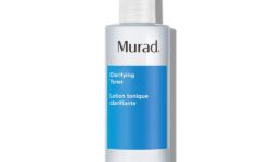 A short cylindrical clear plastic bottle full of some clear liquid with a bright white plastic lid and a bright blue label that has Murad Clarifying Toner written in bright white writing on it, on a white background.