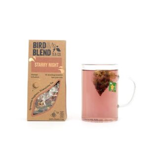 A large rectangular brown cardboard box that has Bird & Blend Tea Company Starry Night Teabag Gift written in bold black writing and a cut out of a large rectangle on it next to a short cylindrical clear glass mug full of some dark brown liquid, on a white background.