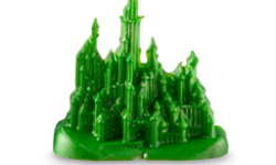 A medium bright lime green city shaped block of soap that has some tall columns and towers on it, on a white background.