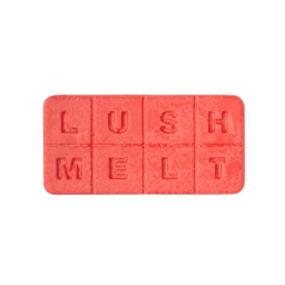 A tall rectangular gradient bright orange and red block of wax that has Lush Melt engraved on it, on a white background.