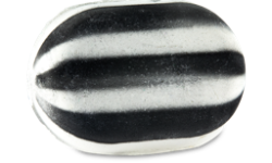 A large bright white and black striped compressed oval sweet shaped bath bomb, on a white background.