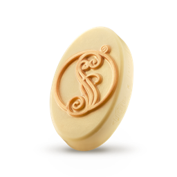 A medium golden yellow block of solid massage oil that has Lush x Wicked and a shimmering golden letter S engraved on it, on a white background.