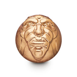 A medium dark green rounded hexagonal shaped bath bomb that has a man’s face with some large eyebrows and wrinkles engraved on it and is covered in some bright gold lustre, on a white background.