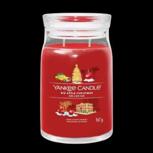 A tall cylindrical glass jar full of some dark red wax with a label that has Yankee Candle written in bright white writing, Big Apple Christmas written in bright white writing, and a picture of a large new york yellow taxi, a large dark green Christmas Tree, a red apple, and a large tree covered in some bright white snow on it, on a white background.
