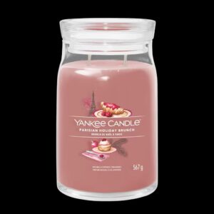 A tall cylindrical glass jar full of some pale pink wax with a label that has Yankee Candle written in bright white writing, Parisian Holiday Brunch written in bright white writing, and a picture of a pile of some golden pancakes covered in some raspberries, a golden brown croissant, and the Eiffel Tower on it, on a white background.