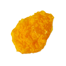 A medium circular puddle of some bright orange shampoo that has some pieces of Course Sea Salt running through it, on a white background.