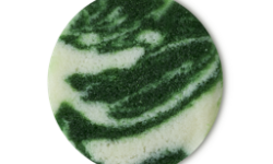 A medium circular puddle of some gradient dark green and white body scrub that has some pieces of Castor Sugar running through it, on a white background.