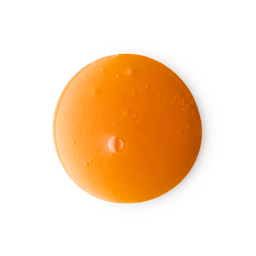 A medium circular puddle of some dark golden caramel shower gel that has some pieces of Gold Lustre running through it, on a white background.