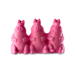 Three medium connected bright pink pigs shaped block of shower jelly that has some dark pink noses and trotters engraved on them and some pieces of Sand embedded in their Bellies, on a white background.