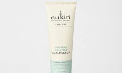 A tall conical creamy white plastic tube with a black plastic lid that has Sukin Balancing Scalp Scrub written in bold black writing on it, on a white background.