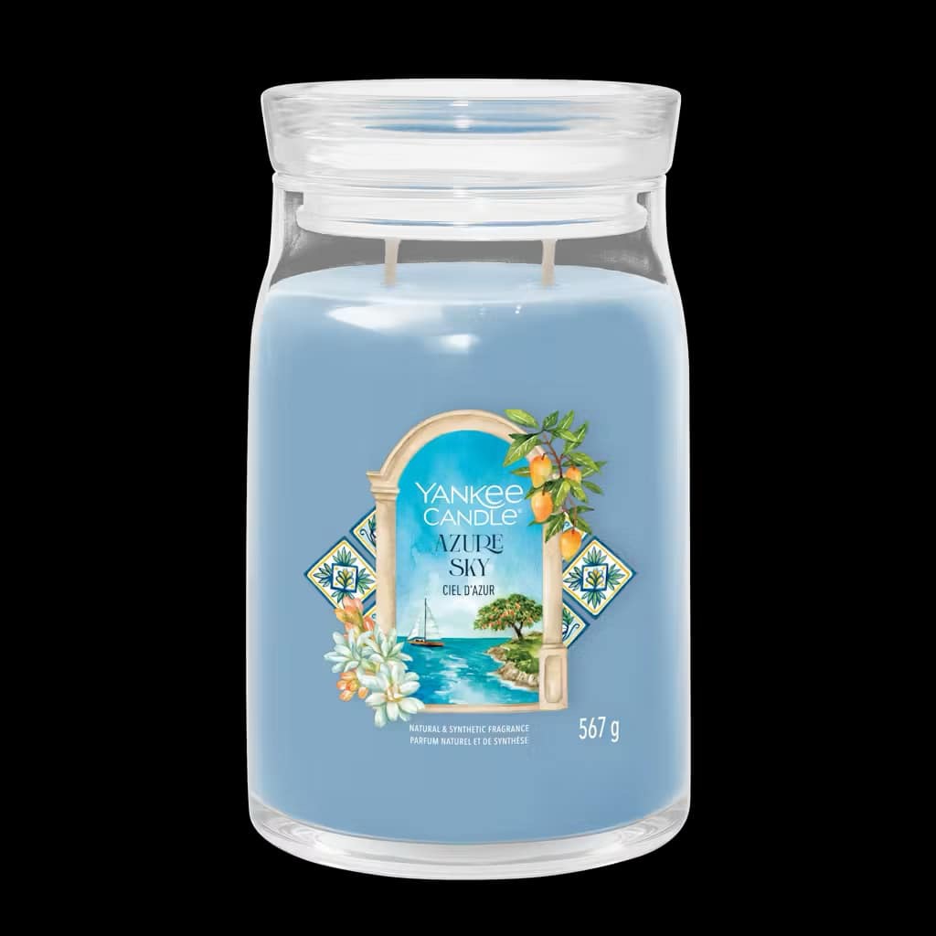 Ciao All'Italia | Yankee Candle Hello To Italy Collection A tall cylindrical glass jar full of some pale blue wax with a label that has Yankee Candle written in bright white writing, Azure Sky written in bright white writing, and a picture of a Sailboat bobbing around on the Water on it, on a white background.
